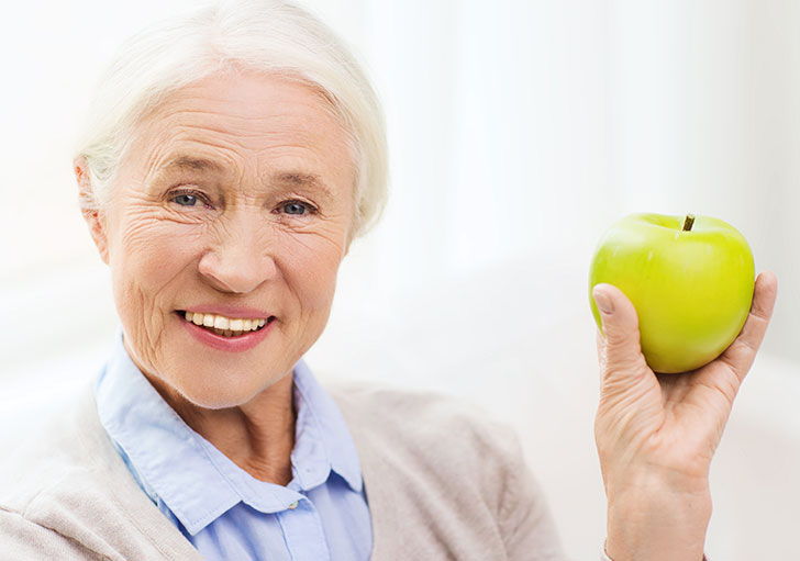 Elder woman holding an apple